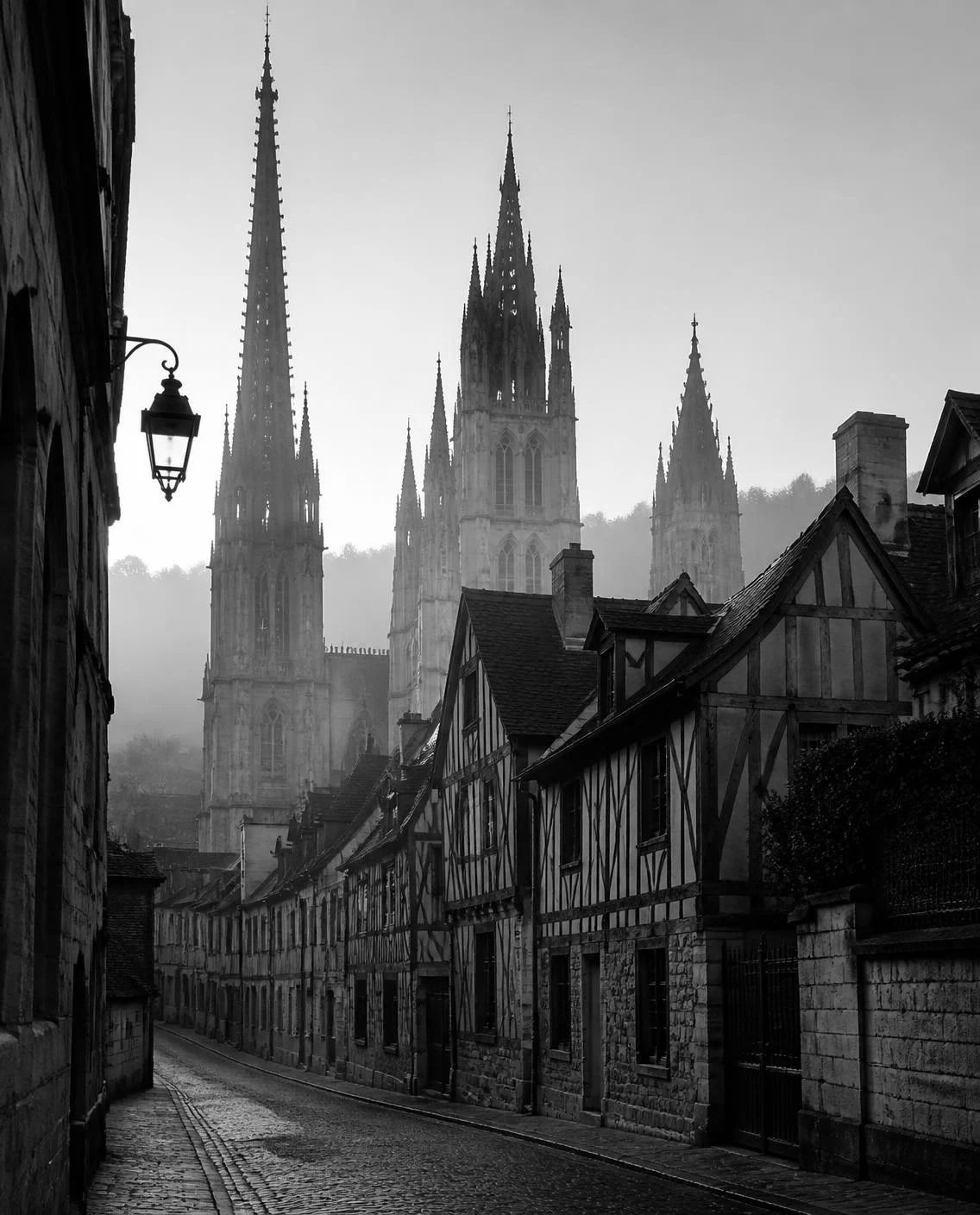 Flèches gothiques de Rouen au-dessus des maisons à colombages, dans la brume du matin